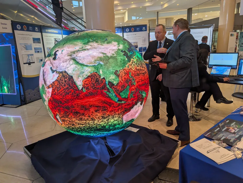 The Ayni sphere showing ocean currents while two delegates discuss it at the assembly